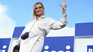 Una persona saluta con un gesto durante un evento televisivo all'aperto