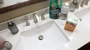 Lavandino da bagno con bicarbonato, aceto e prodotto per tubature sul piano