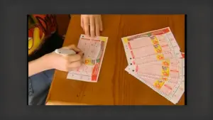Persona che compila una schedina del Superenalotto su un tavolo di legno