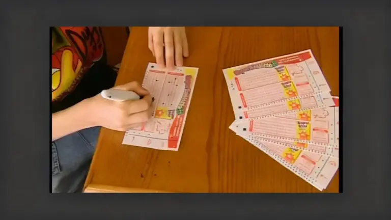Persona che compila una schedina del Superenalotto su un tavolo di legno