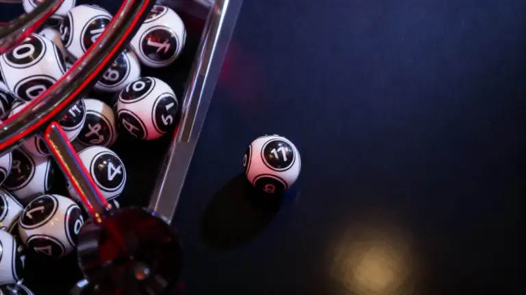 Palline numerate da lotteria su una superficie scura, una separata dal gruppo